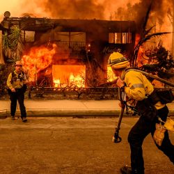Los bomberos trabajan en el lugar mientras un edificio de apartamentos arde durante el incendio de Eaton en el área de Altadena del condado de Los Ángeles, California. | Foto:JOSH EDELSON / AFP