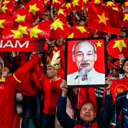 Los hinchas levantan un sombrero cónico asiático con los colores vietnamitas y un retrato de Ho Chi Minh antes del inicio del partido de ida de la final de la Copa Eléctrica de la ASEAN 2024 entre Vietnam y Tailandia en el Estadio Viet Tri en la provincia de Phu Tho. | Foto:NHAC NGUYEN / AFP