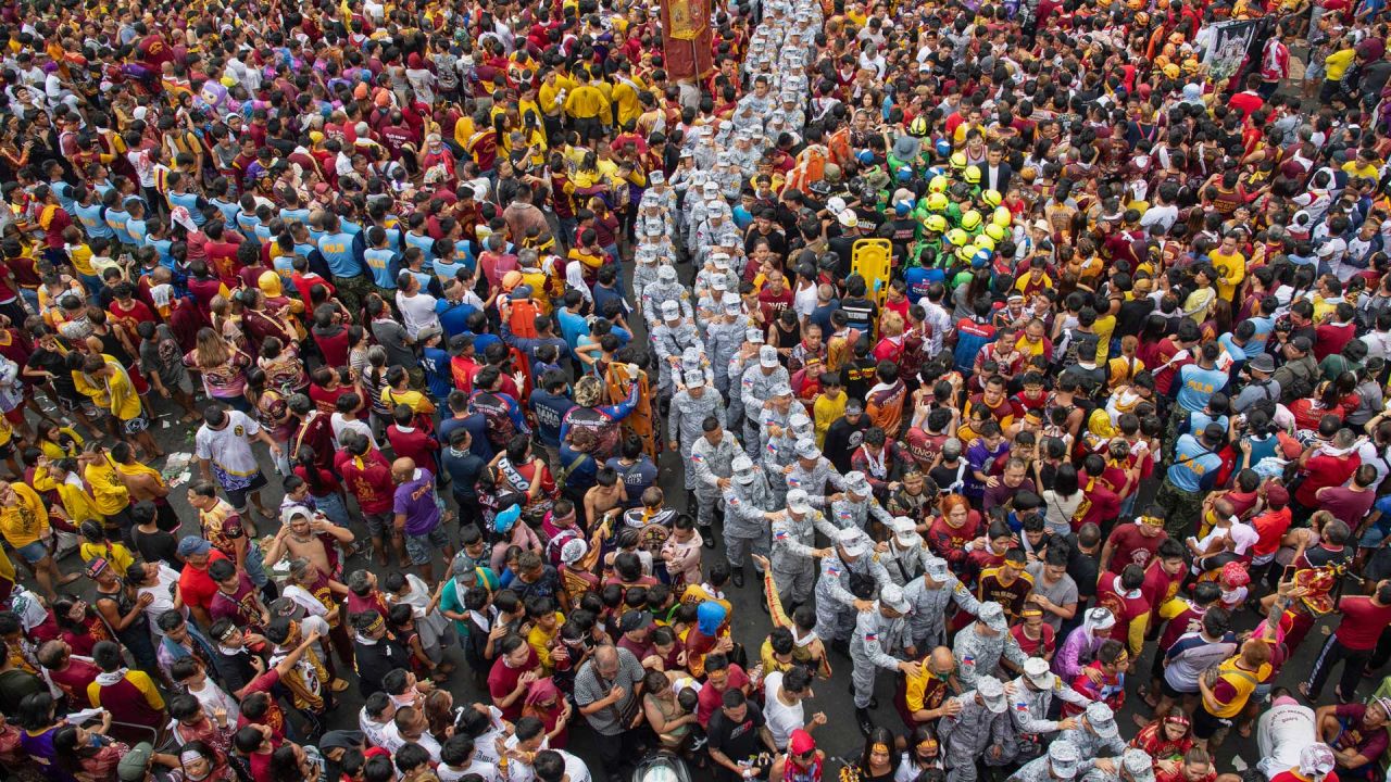 El personal militar camina entre los devotos católicos durante la procesión religiosa anual del Nazareno Negro en Manila, Filipinas. | Foto:TED ALJIBE / AFP