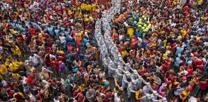 El personal militar camina entre los devotos católicos durante la procesión religiosa anual del Nazareno Negro en Manila, Filipinas.