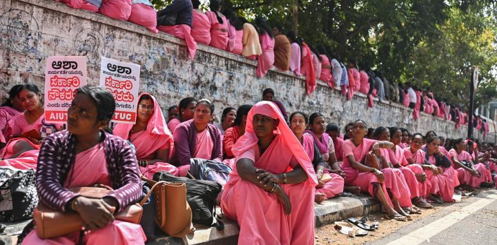 Los trabajadores de la Activista Social de Salud Acreditada (ASHA) de Karnataka se sientan en una calle mientras participan en una protesta indefinida exigiendo un aumento en el pago de honorarios y el desembolso inmediato de las cuotas pendientes de tres meses, en Freedom Park en Bengaluru, India.