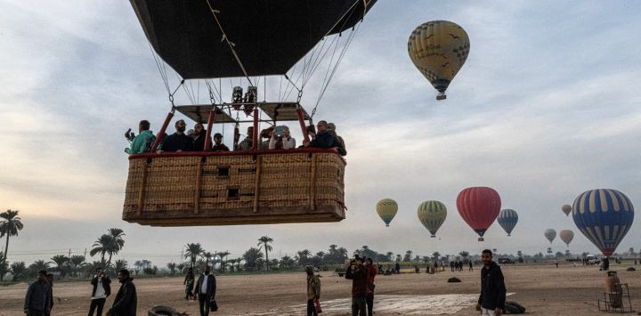 Un globo aerostático despega con turistas en su canasta antes de volar sobre la orilla oeste del río Nilo en la ciudad de Luxor, en el sur de Egipto.