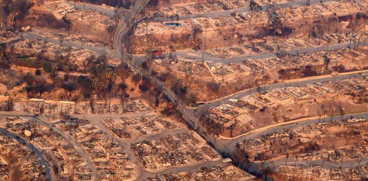 En esta vista aérea tomada desde un helicóptero, las casas quemadas por el incendio de Palisade arden sin llama cerca del vecindario Pacific Palisades de Los Ángeles, California.