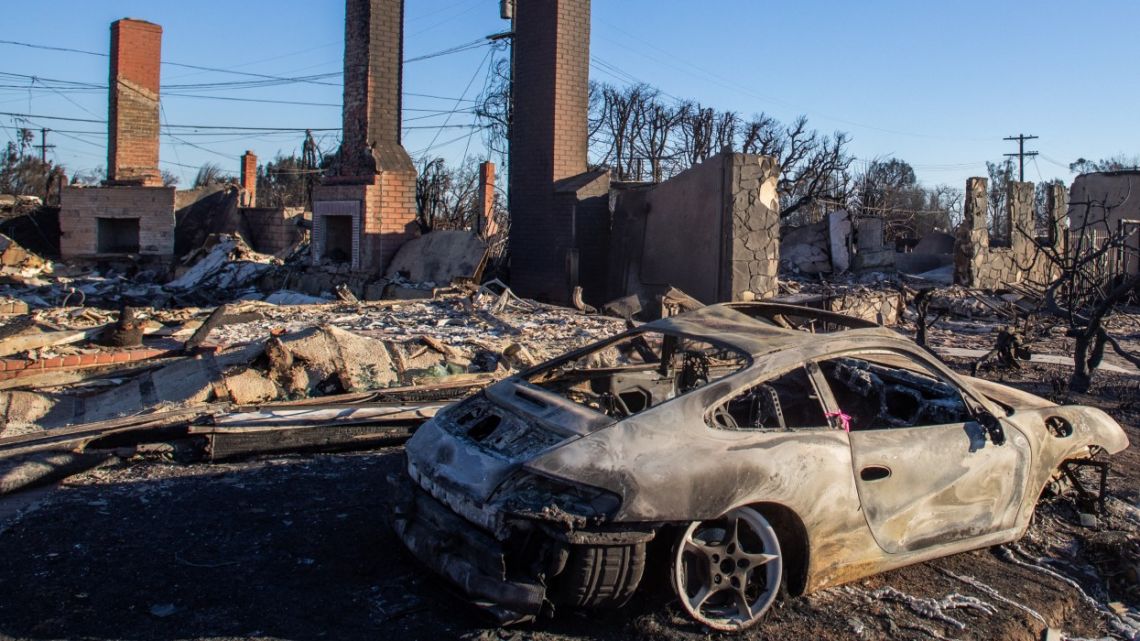 A car and homes burned by the Palisades Fire are seen on January 12, 2025 in the Pacific Palisades neighborhood of Los Angeles, California.