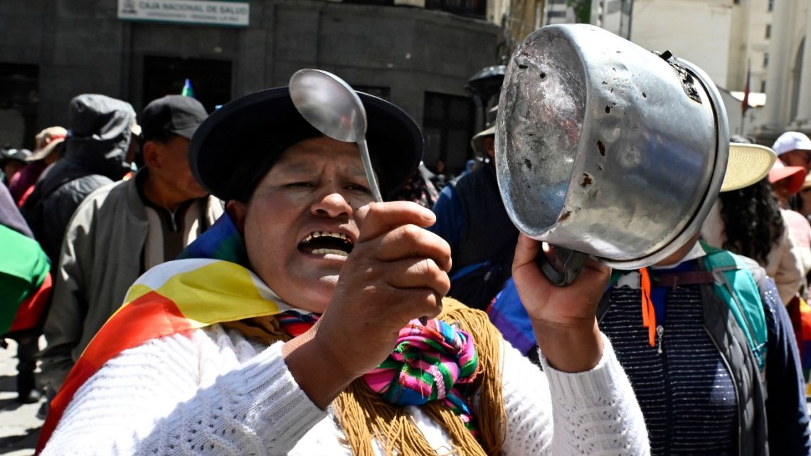 A supporter of Bolivia's former president, Evo Morales, bangs a pot during the ‘Communal for Life’ march against the government of Luis Arce and to denounce the economic crisis outside the vice-presidency building in La Paz on January 13, 2025.