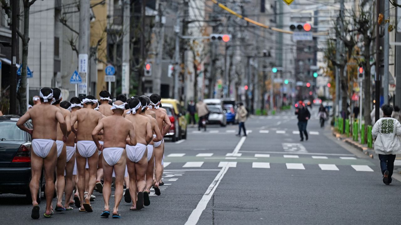 Los creyentes sintoístas del santuario Teppozu Inari corren alrededor del santuario para calentarse antes de tomar un baño en agua fría para purificar sus almas y cuerpos durante un ritual anual de Año Nuevo en Tokio. | Foto:Richard A. Brooks / AFP