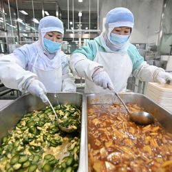 Imagen de empleadas empaquetando alimentos en un centro de lavado y abastecimiento de China Railway Taiyuan Group Co., Ltd., en Jinzhong, en la provincia de Shanxi, en el norte de China. | Foto:Xinhua/Zhan Yan