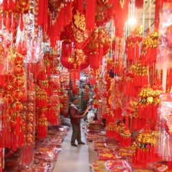 Imagen de un hombre comprando decoraciones del Año Nuevo chino en una tienda, en Phnom Penh, Camboya. | Foto:Xinhua/Phearum