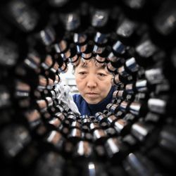 Imagen del montador de vehículos Li Weiping revisando el eje en el taller de ruedas y ejes Railway Taiyuan Group Co., Ltd., en Taiyuan, en la provincia de Shanxi, en el norte de China. | Foto:Xinhua/Yang Chenguang