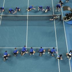 Los recogepelotas secan la cancha durante una demora por lluvia en el partido individual masculino entre el serbio Novak Djokovic y el portugués Jaime Faria en el cuarto día del torneo de tenis Abierto de Australia en Melbourne. | Foto:Adrian Dennis / AFP