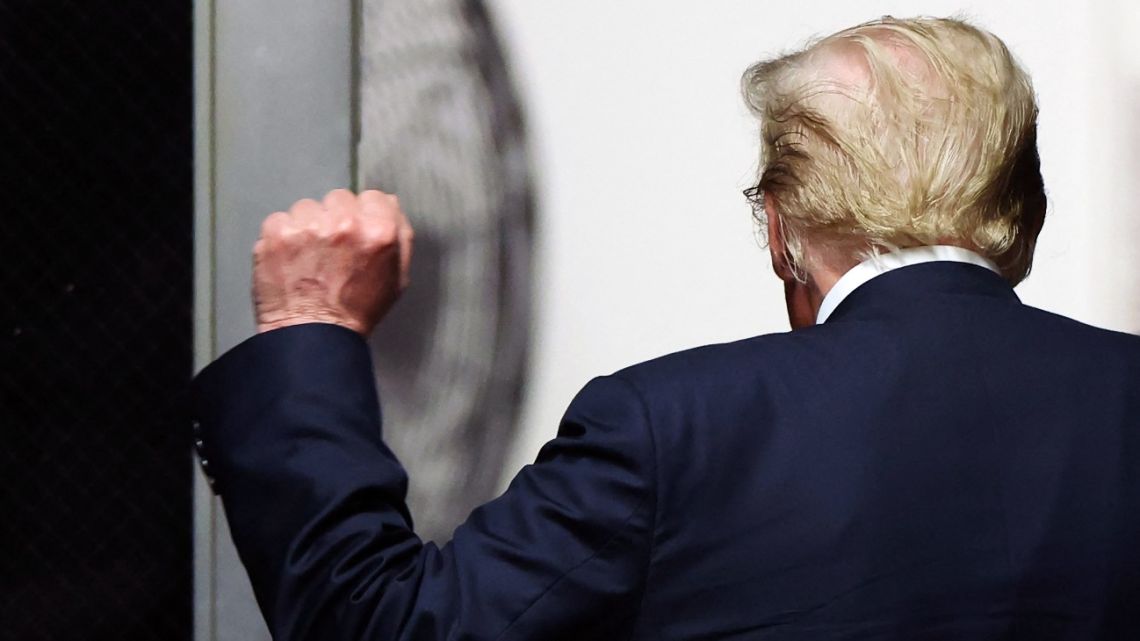 Former US President and Republican presidential candidate Donald Trump holds up a fist as he walks to the courtroom after the start of deliberations in his criminal trial at Manhattan Criminal Court in New York City, on May 29, 2024.