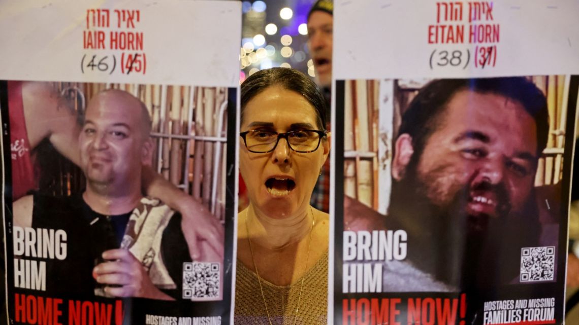 A demonstrator raises placards during a protest calling for action to secure the release of Israelis held hostage in Gaza since October 2023, in front of the Israeli defence ministry in Tel Aviv on January 14, 2025.