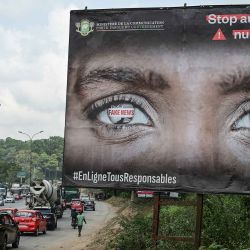 Los automovilistas pasan frente a un cartel de sensibilización sobre Fake News al costado de una carretera en Abiyán. Foto de Sia KAMBOU / AFP | Foto:AFP