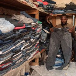 Un vendedor dobla pantalones en su tienda del mercado Mixebo de Cotonú. Foto de Eustache Ahomagnon / AFP | Foto:AFP
