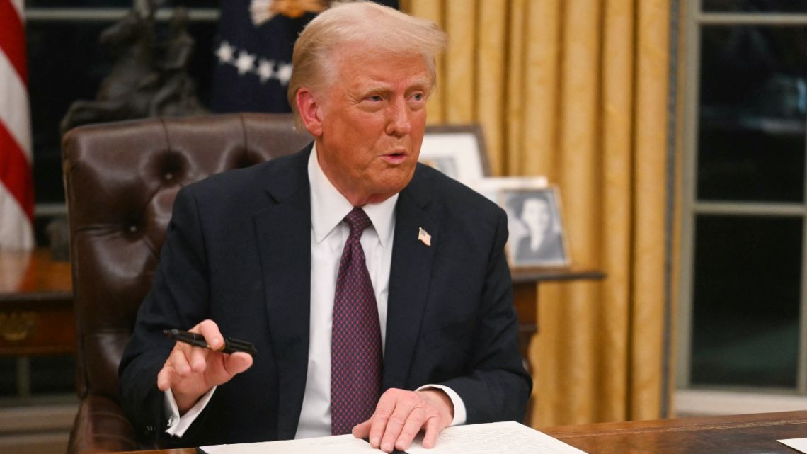 US President Donald Trump signs an executive order on the US withdrawal from WHO in the Oval Office of the White House in Washington, DC, on January 20, 2025.