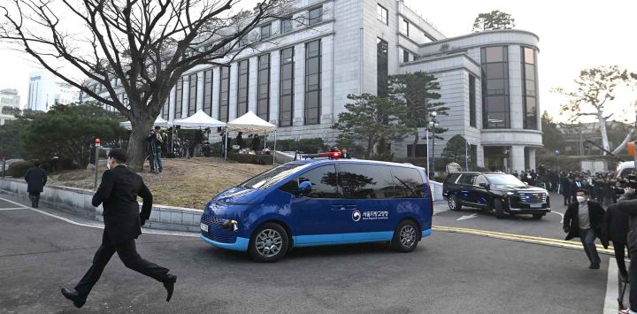 Una camioneta azul que se cree transportaba al presidente de Corea del Sur, Yoon Suk Yeol, sale del Tribunal Constitucional en Seúl. Foto de Jung Yeon-je / AFP 