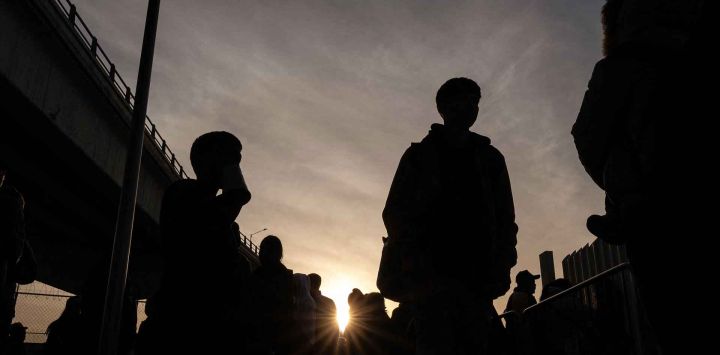 Solicitantes de asilo esperan sus citas con las autoridades estadounidenses en la CBP One antes de cruzar por el puerto de El Chaparral en Tijuana, México. Foto de Guillermo Arias / AFP