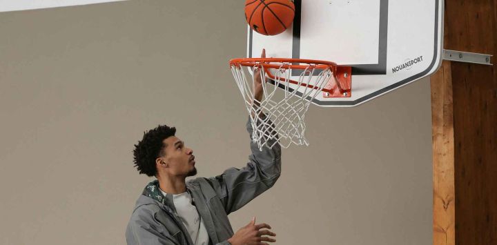 El delantero francés de los San Antonio Spurs, Victor Wembanyama, lanza el balón en un aro durante la inauguración de las canchas de baloncesto en Le Chesnay. Foto de Thomas SAMSON / AFP