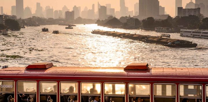 Un autobús circula por un puente sobre el río Chao Phraya en medio de altos niveles de contaminación del aire en Bangkok. Foto de Chanakarn Laosarakham / AFP