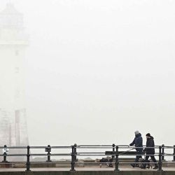 La gente camina por el paseo marítimo cerca del faro envuelto en niebla en New Brighton, en el noroeste de Inglaterra. Foto de Paul ELLIS / AFP, en el noroeste de Inglaterra. Foto de Paul ELLIS / AFP | Foto:AFP