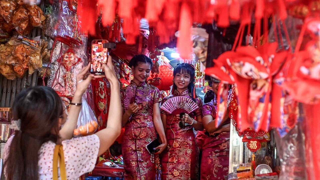 Los visitantes posan para fotos junto a decoraciones festivas a la venta para el próximo Año Nuevo Lunar en una tienda en Yangon. Foto de Sai Aung MAIN / AFP | Foto:AFP