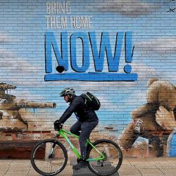 Un hombre pasa en bicicleta junto a un grafiti en la pared de la ciudad israelí de Kfar Saba. Foto de Jack GUEZ / AFP | Foto:AFP