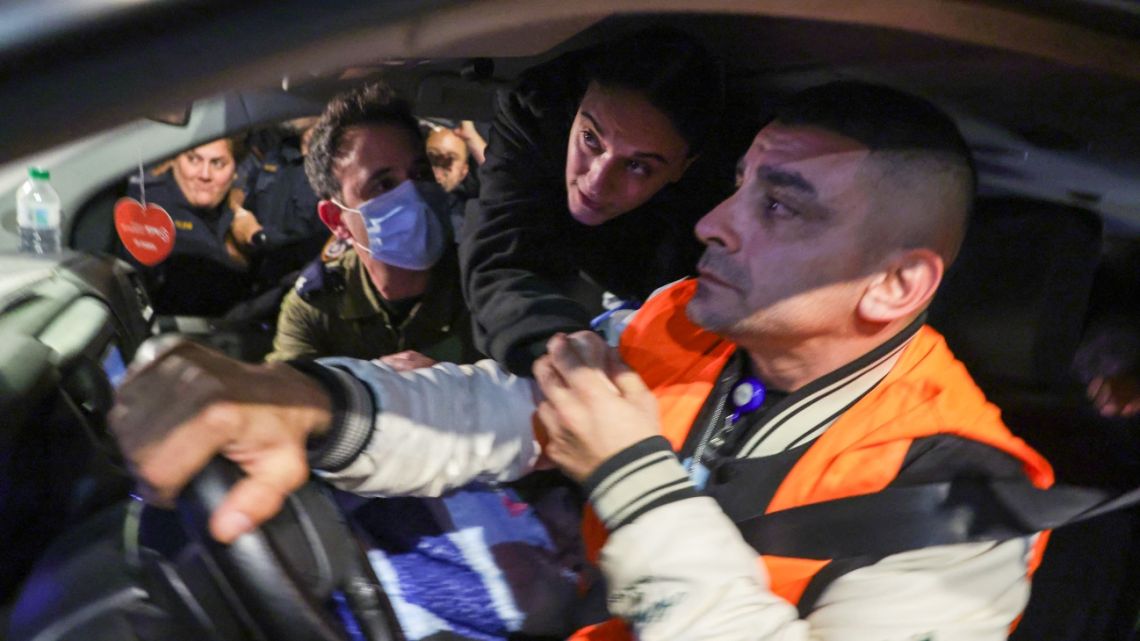 Emily Damari reaches to shake hands with her friends while being transported with two other hostages upon arriving at Sheba Tel HaShomer Medical Centre in Ramat Gan on January 19, 2025, following their release from captivity by Hamas.