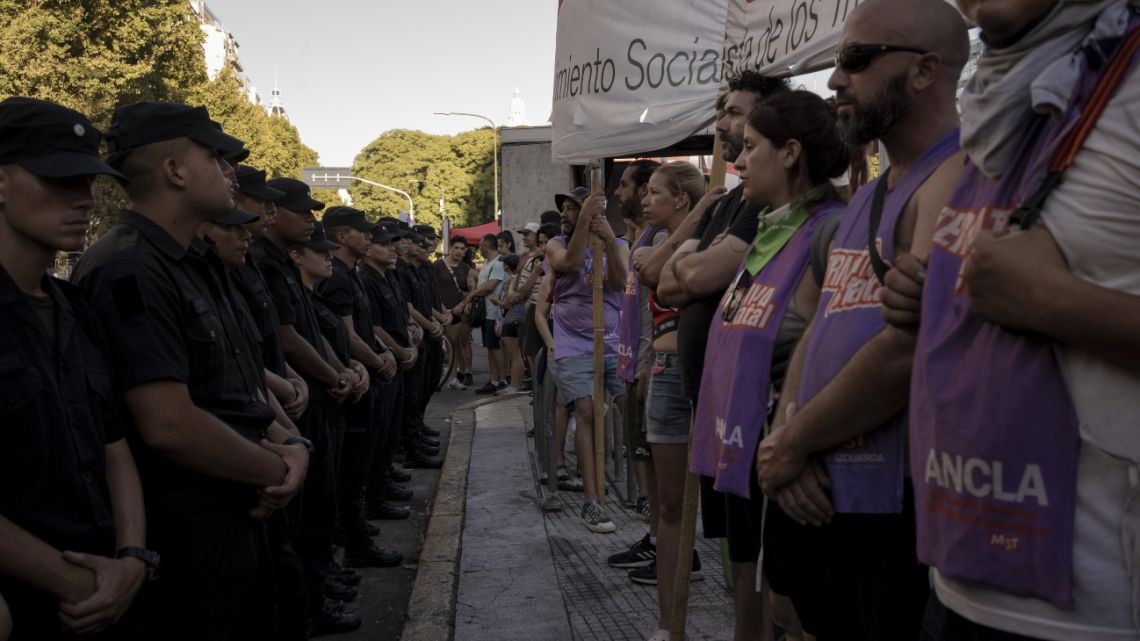 Members of the Argentine Federal Police (PFA) stand guard during a protest against the 