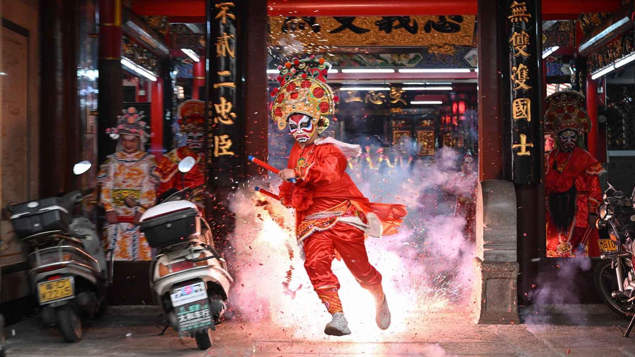 Una bailarina de Yingge sostiene un petardo mientras sale corriendo de un templo ancestral durante una actuación en Shantou, en la provincia de Guangdong. Foto de JADE GAO / AFP | Foto:AFP