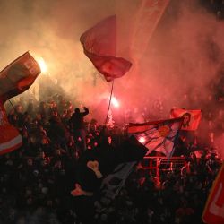 Los hinchas del Crvena Zvezda encienden bengalas y ondean banderas gigantes mientras animan a su equipo desde las gradas durante el partido de fútbol de la jornada 7 de la fase de liga de la UEFA Champions League entre el FK Crvena Zvezda (SRB) y el PSV Eindhoven (NED) en el estadio Rajko Mitic en Belgrado. | Foto:Andrej ISAKOVIC / AFP