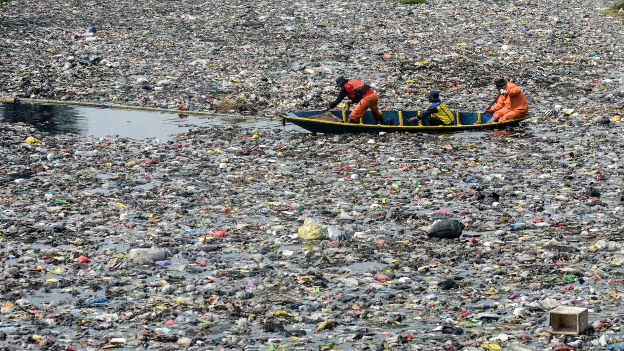 Voluntarios y funcionarios de la Agencia de Gestión de la Gran Cuenca del Río (BBWS) de Citarum limpian los escombros flotantes atrapados por cañas de bambú en el río Citarum en Bandung, Java Occidental, Indonesia. | Foto:TIMUR MATAHARI / AFP