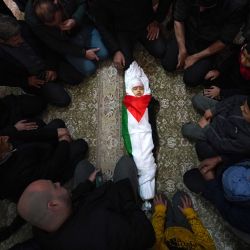 Los dolientes rodean el cuerpo envuelto en una bandera de Laila al-Khatib, de dos años, mientras yace en una mezquita, un día después de que sucumbiera a sus heridas luego de recibir un disparo durante una redada militar israelí en Jenin, en la Cisjordania ocupada, antes de su funeral. | Foto:AFP