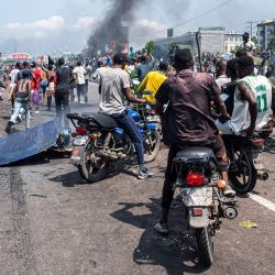 Manifestantes se reúnen mientras se elevan columnas de humo de neumáticos en llamas durante una manifestación contra el conflicto que se intensifica en el este de la República Democrática del Congo en Kinshasa. | Foto:Hardy Bope / AFP