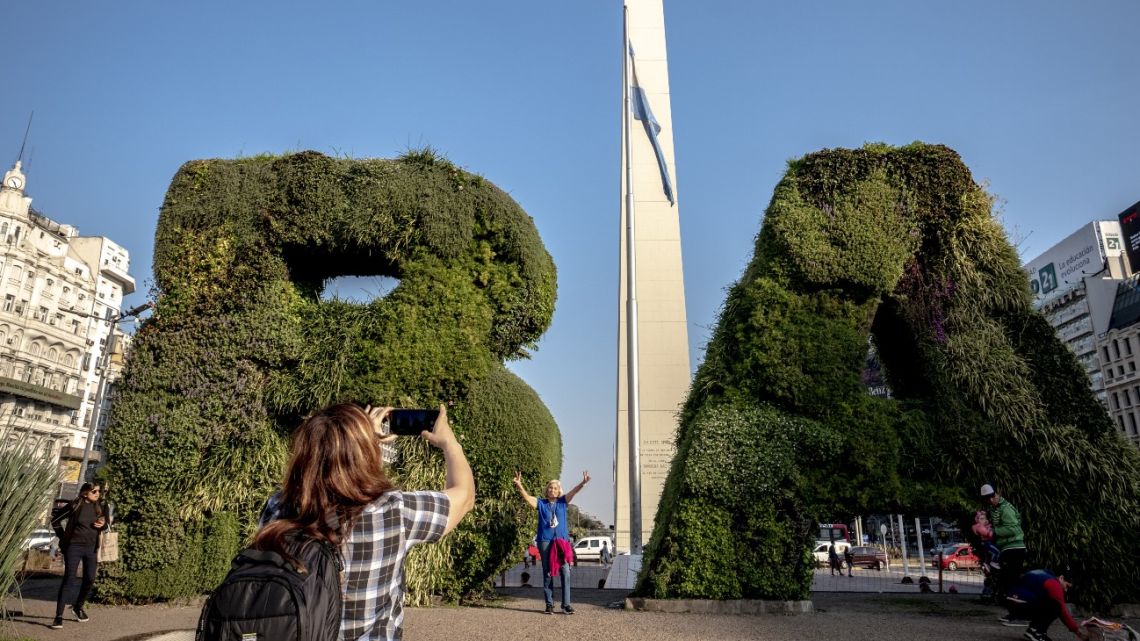 Tourists take photos in front of the Obelisk in Buenos Aires.