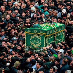 Peregrinos musulmanes chiítas marchan con un ataúd simbólico frente al santuario del imán Musa al-Kadhim, del siglo VIII, durante la conmemoración anual de su muerte, según el calendario musulmán Hijri, en el distrito de Kadhimiya, en el norte de Bagdad. | Foto:AHMAD AL-RUBAYE / AFP