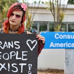 Un miembro de la comunidad LGBTQ sostiene un cartel durante una protesta contra el presidente estadounidense Donald Trump frente a la embajada de Estados Unidos en Brasilia. El presidente estadounidense Donald Trump firmó una orden ejecutiva para restringir los procedimientos de transición de género para personas menores de 19 años, en su última medida dirigida a las personas transgénero desde que regresó al cargo. | Foto:EVARISTO SA / AFP