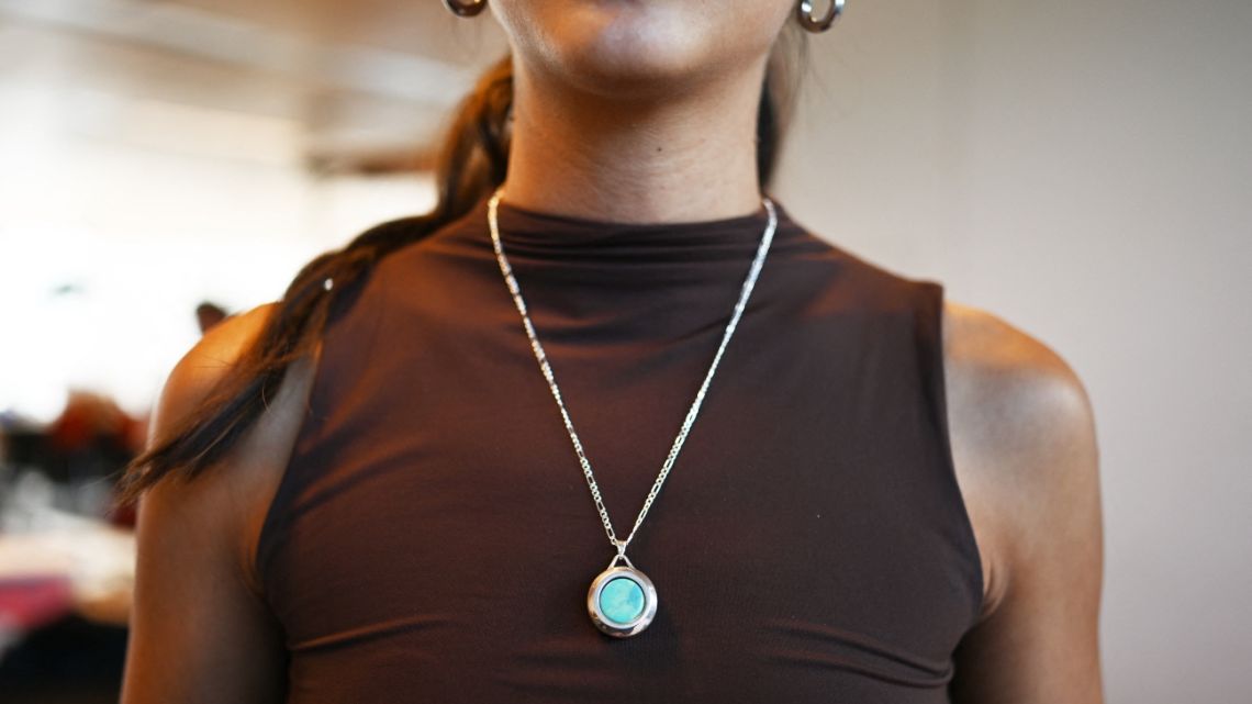 A young woman wears a necklace with an inserted emergency button that alerts emergency contacts at the premises of Chilean startup Alara in Santiago on January 14, 2025.