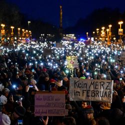 Los manifestantes usan las luces de sus teléfonos móviles durante una manifestación bajo el lema "Alto contra los nazis" frente a la sede de la Unión Demócrata Cristiana (CDU) en Berlín. | Foto:JOHN MACDOUGALL / AFP
