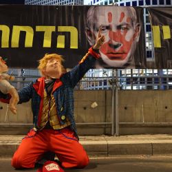 Un manifestante con una máscara de Donald Trump sostiene un muñeco con una máscara del primer ministro israelí, Benjamin Netanyahu, durante una protesta para pedir la liberación de los rehenes cautivos en Gaza desde el ataque del 7 de octubre de 2024 por militantes palestinos, frente al Ministerio de Defensa israelí en Tel Aviv. | Foto:JACK GUEZ / AFP