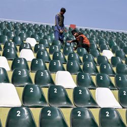 Los trabajadores pintan con aerosol la zona de asientos del estadio de críquet de Rawalpindi, en Pakistán, antes del torneo de críquet ICC Champions Trophy 2025. | Foto:Farooq Naeem / AFP