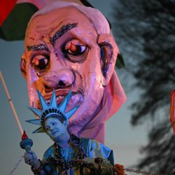 Un activista vestido como la Estatua de la Libertad es atado con grilletes cerca de una gran efigie del primer ministro israelí, Benjamin Netanyahu, mientras se manifiestan en apoyo de los palestinos durante la "Atención a Netanyahu en la manifestación de la Casa Blanca" cerca de la Casa Blanca en Washington, DC. | Foto:Mandel Ngan / AFP