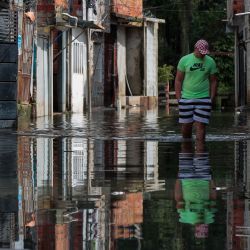Un hombre camina por las aguas inundadas en el barrio Jardim Pantanal, en Sao Paulo después de las fuertes lluvias. | Foto:MIGUEL SCHINCARIOL / AFP