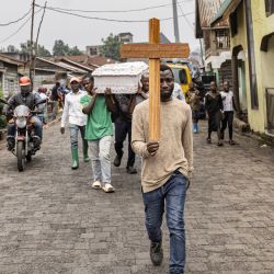 Un hombre lleva una cruz durante una procesión fúnebre hacia el cementerio ITIG en Goma, donde se han cavado tumbas nuevas para alojar a las víctimas de la reciente violencia. El grupo armado M23, respaldado por Ruanda, anunció un "alto el fuego" humanitario en el este perennemente explosivo de la República Democrática del Congo, días antes de una reunión de crisis prevista entre los líderes congoleños y ruandeses. | Foto:Michel Lunanga / AFP