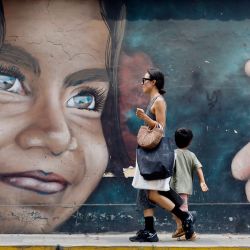 Una mujer y un niño caminan frente a un mural, en el distrito de Barranco, en Lima, Perú. | Foto:Xinhua/Mariana Bazo