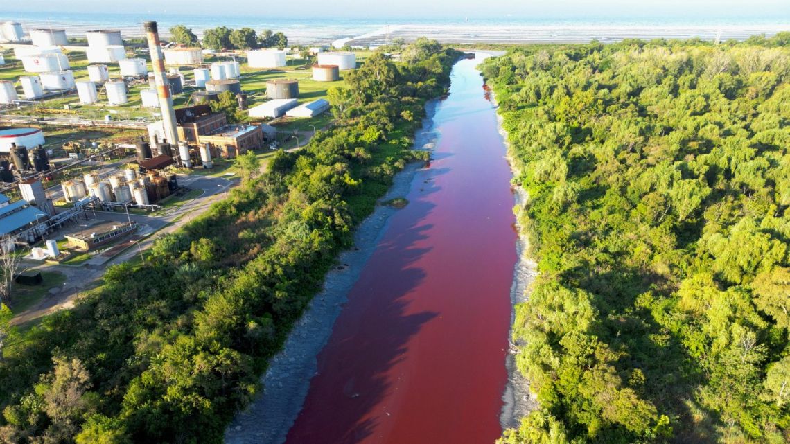 This aerial view shows the unusual reddish colour of the Sarandí Canal seeping into the Río de la Plata River in Sarandí, Avellaneda on the outskirts of Buenos Aires on February 6, 2025.