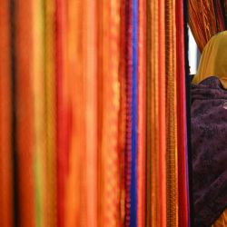 Una vendedora habla por teléfono móvil mientras vende hilos sagrados durante el festival Maha Kumbh Mela en Prayagraj, India. | Foto:IDREES MOHAMMED / AFP