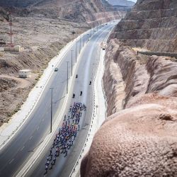 El grupo de ciclistas avanza durante la primera etapa del Tour de Omán, desde Bushar hasta el sumidero de Bimmah, en la provincia oriental de Mascate. | Foto:LOIC VENANCE / AFP