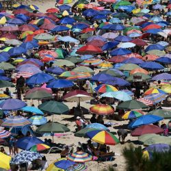 La gente disfruta del día en la playa El Canelo cerca de Algarrobo, provincia de Valparaíso, en la costa central de Chile. | Foto:RODRIGO ARANGUA / AFP