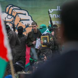 Los combatientes palestinos de Hamás escoltan al rehén israelí Or Levy fuera de un escenario antes de entregarlo a un equipo de la Cruz Roja mientras la gente se reúne para observarlo en Deir el-Balah, en el centro de Gaza, como parte del quinto intercambio de rehenes y prisioneros de un frágil alto el fuego. | Foto:Bashar Taleb / AFP