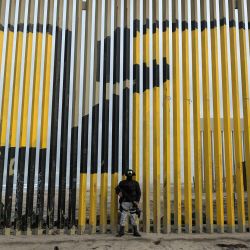 Un oficial de la Guardia Nacional de México, parte de la Operación Frontera Norte, hace guardia junto al muro fronterizo entre México y Estados Unidos en Playas de Tijuana, estado de Baja California, México. México comenzó el despliegue de 10.000 efectivos fronterizos que había prometido al presidente estadounidense Donald Trump a cambio de retrasar un arancel del 25 por ciento a los bienes exportados, dijo la presidenta Claudia Sheinbaum. | Foto:Guillermo Arias / AFP
